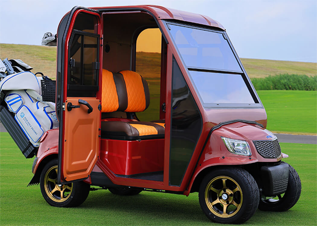 ドアを開けた状態のAirCon Cart。2人乗りシートとゴルフバッグを積んだ赤い車体