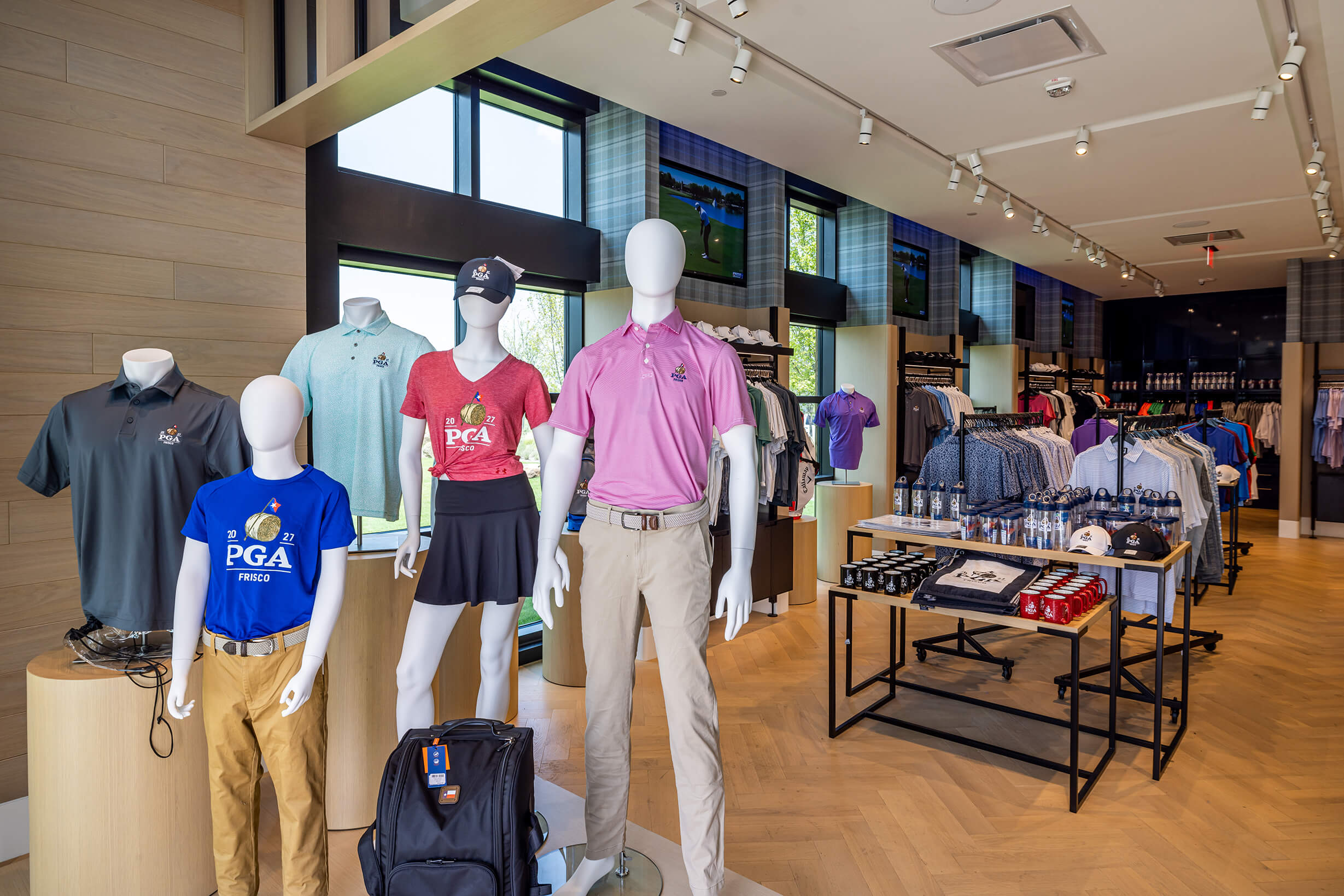 PGA Friscoのプロショップ店内。マネキンに着せたポロシャツ、ラックに並ぶウェア、小物を並べた什器