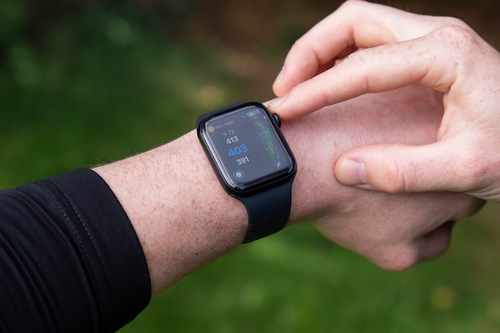 コース上でApple Watchの画面を操作するゴルファーの手元。グリーンまでの距離が表示されている