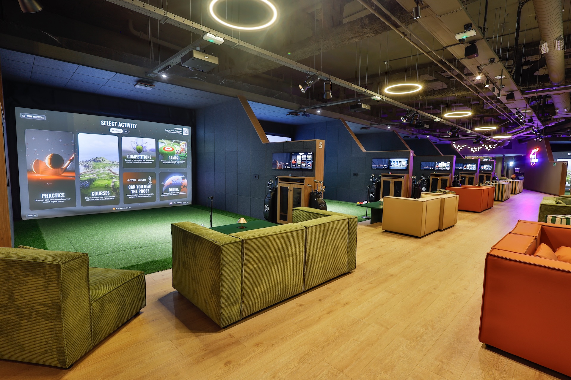 Five Iron Golfマドリード店のトラックマン打席と、打席の前に並ぶソファ席