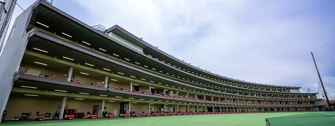 トーキョージャンボゴルフセンター 4階建て打席棟（弧状）とレンジ