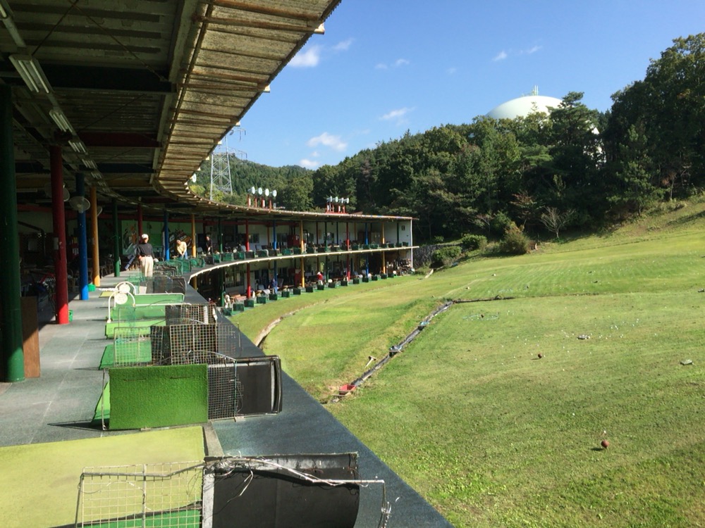 二軒茶屋ゴルフ倶楽部 カーブした屋根付き打席と天然芝のレンジ