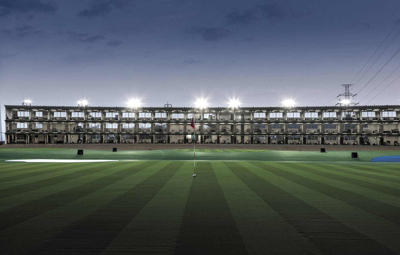 PXG大阪ドライビングレンジ 夜間照明の3階建て打席棟とフィールド