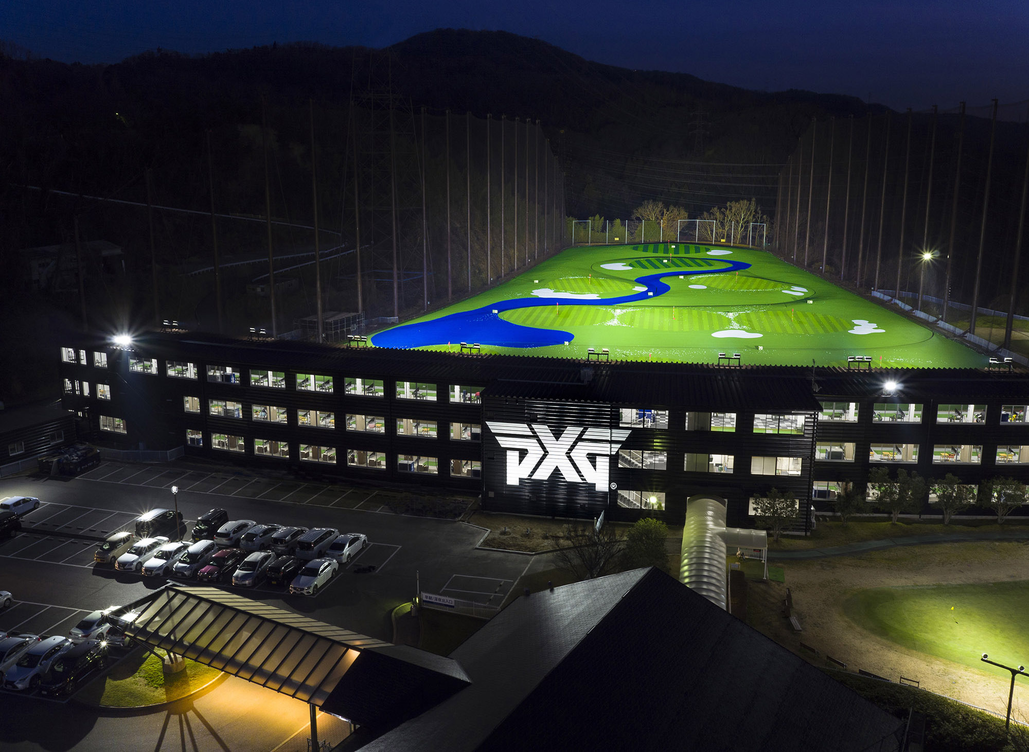 PXG大阪ドライビングレンジ 夜景の施設全景(打席棟と照明付きフィールド)