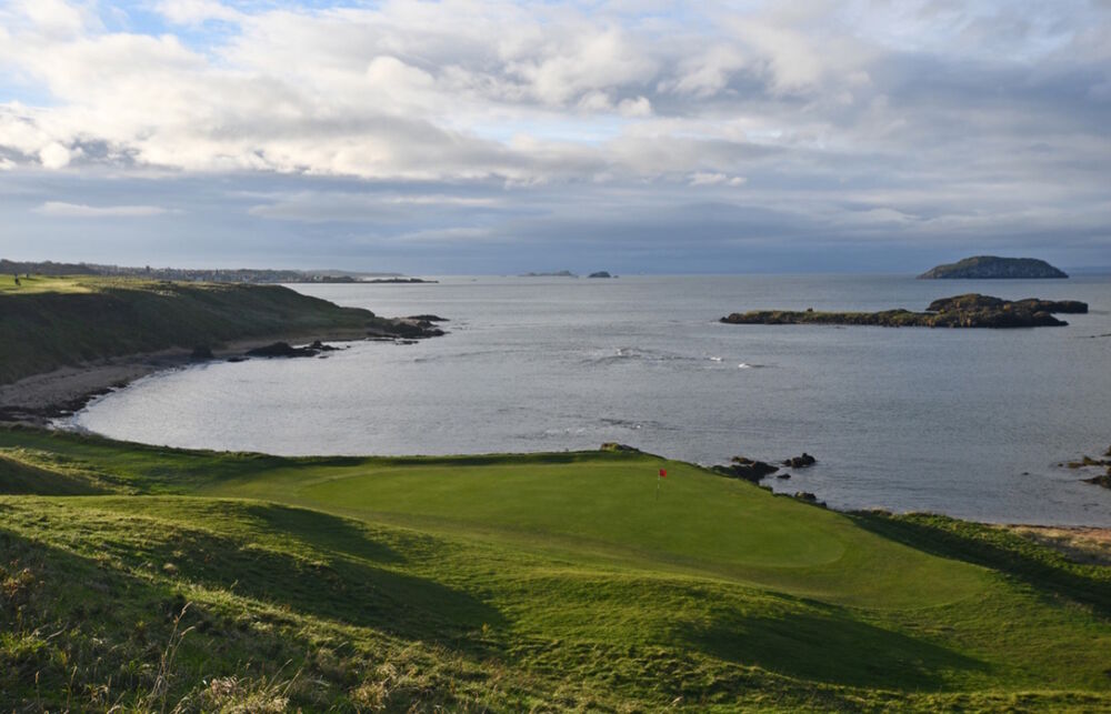 海に面した崖の上にあるThe Glen Golf Clubのグリーンと、沖に浮かぶ島々